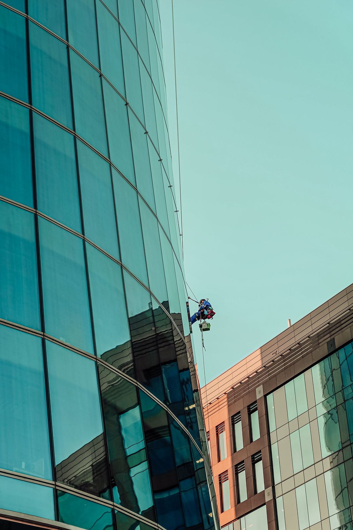 Rope-access operative on a curved glass tower